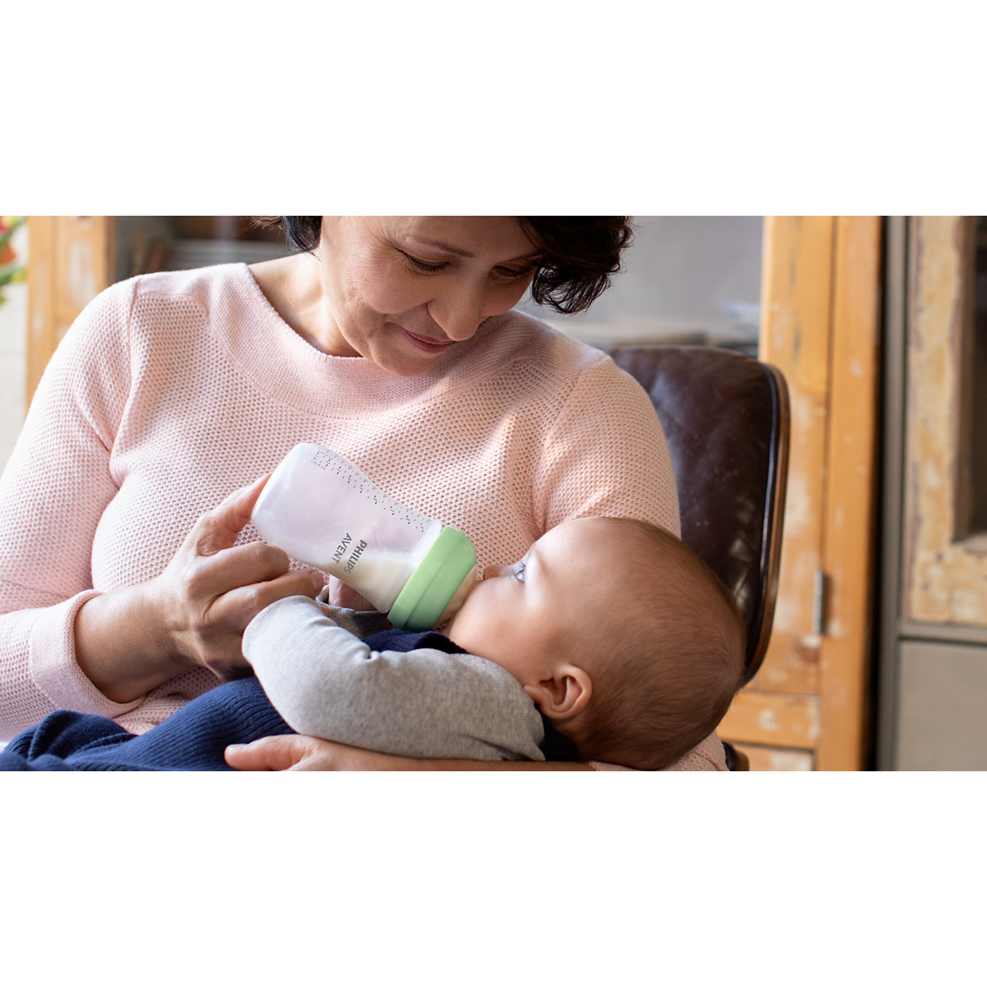 Woman feeding a baby with a bottle in a home setting