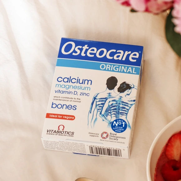 Osteocare supplement box on a table with a bowl of fruit