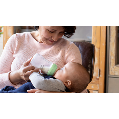 Woman feeding a baby with a bottle in a home setting